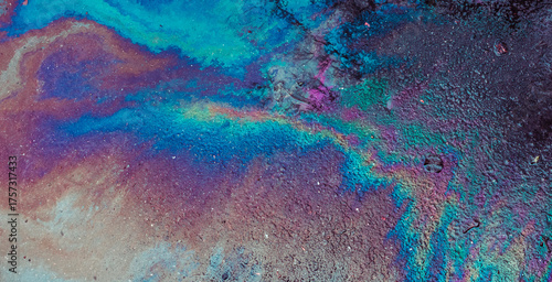 Принти на полотні Oil spill on asphalt creating a colorful abstract pattern reflecting light with