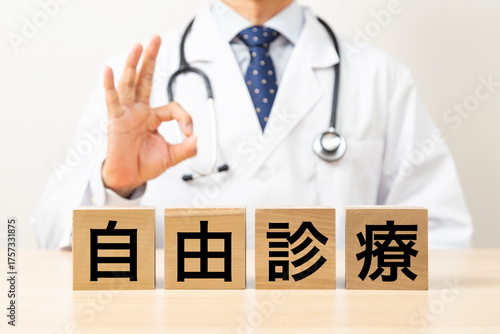 「自由診療」と書かれたブロックとOKサインをする医師
