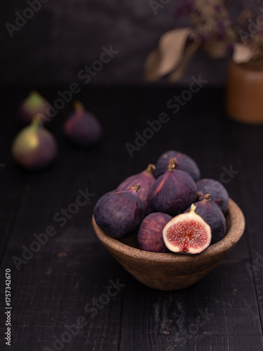 Sliced Fig in Wooden Bowl with Whole Figs on Dark Background