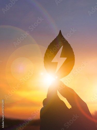 Hand Holding Eco Leaf with Energy Symbol at Sunset Renewable Power Concept