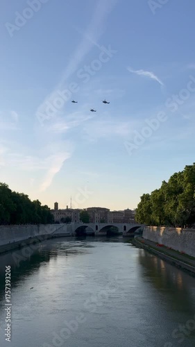 Three military helicopters fly in formation across the sky above Rome's historic center.