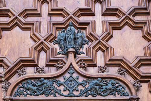 Wooden door with ornate carvings and religious reliefs