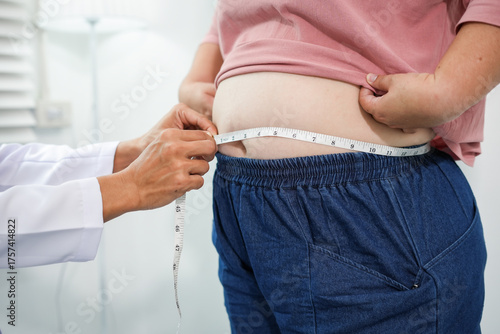 Tableau sur toile A doctor measures an Asian woman's waist during a routine health check-up to assess abdominal fat, obesity risk, and overall health status as part of preventive healthcare and weight management