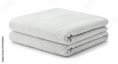 Two neatly folded white towels are stacked on a white surface casting a slight shadow