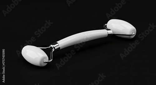 White facial roller with chrome details on a black surface