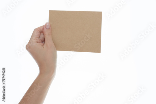 Woman's Hand Holding Blank Brown Kraft Paper Card on Isolated White Background