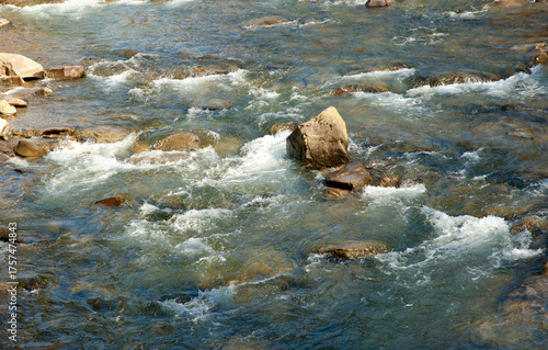 Fragment of a wide mountain river with a rocky bottom
