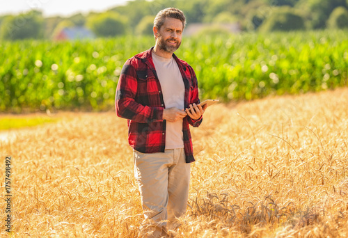 Farmer agronomist man with tablet in field. Technology of modern agriculture. Farmer man working on field with tablet. Hispanic farmer with tablet check harvest. Crop harvest