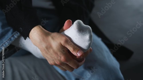 A foot injury from a strong blow.
A man sits on a sofa wearing white socks and clutches his sore heel.
Close-up of the injured heel.
Pain, medicine, health, bruise