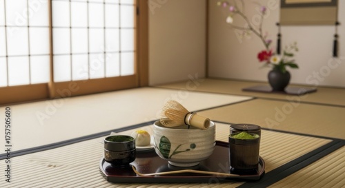 A traditional Japanese tea ceremony setup with a white and brown mat, a wooden door, and a vase with flowers.