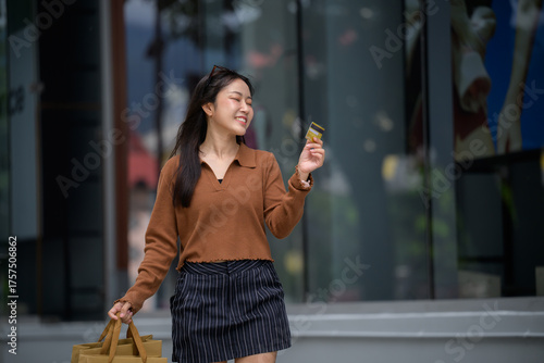 Cuadro en lienzo Smiling woman holding credit card and shopping bags