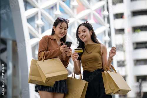 Women friends shopping online with smartphone credit card