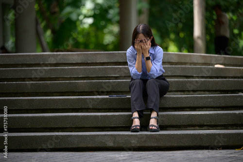 Woman experiencing stress and despair crying on stairs
