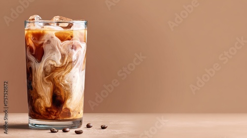 iced coffee in clear glass with milk brown background
