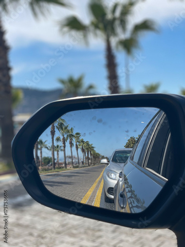 Fotografie Palm Trees Reflected In Car Side Mirror On Sunny Road Outdoors, Concept Of Trave