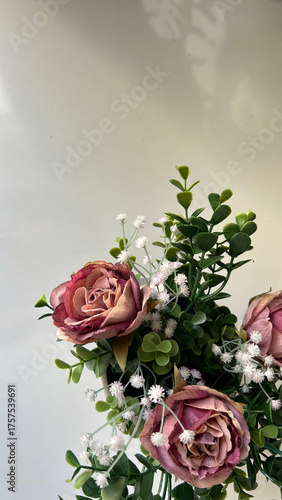 Fotografie Dried Pink Roses With Green Leaves On Light Background Indoors, Concept Of Vinta