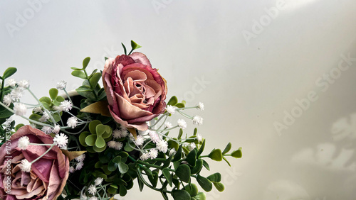 Fotografie Dried Pink Roses With Green Leaves On Light Background Indoors, Concept Of Vinta