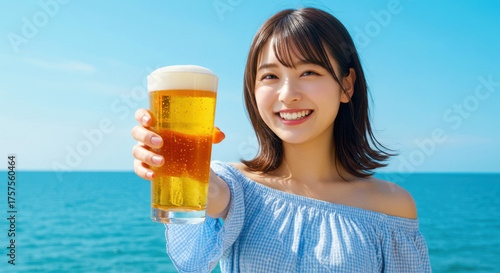 青空を背景に海辺で乾杯する爽やかな若い女性