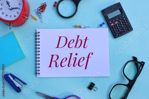 Debt relief text on notebook with blue background. Debt Relief concept.