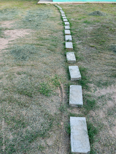 Concrete Brick Pathway Across Grass Lawn to Home.