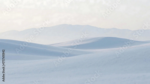 A tranquil snowy scene featuring gentle dunes and hazy mountains under a light sky.