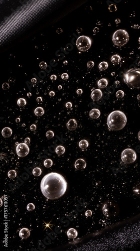 Macro view of shiny metallic spheres floating in dark space, concept of physics, molecules, and abstract futuristic background.