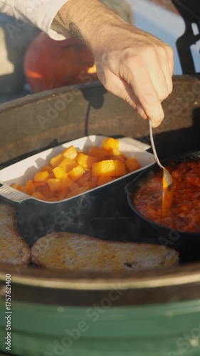 A person is cooking food in a pan with a spoon. The food is red and he is chili