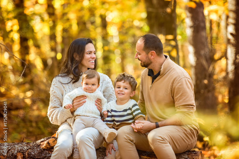 Fototapeta premium Beautiful young family on a walk in autumn forest