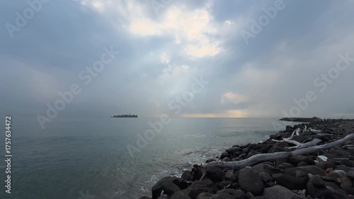 Isla entre la bruma y rayos de luz 
