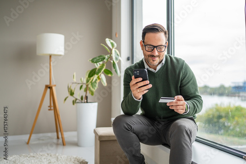 Fotografie Man making secure online payment using smart phone and credit card
