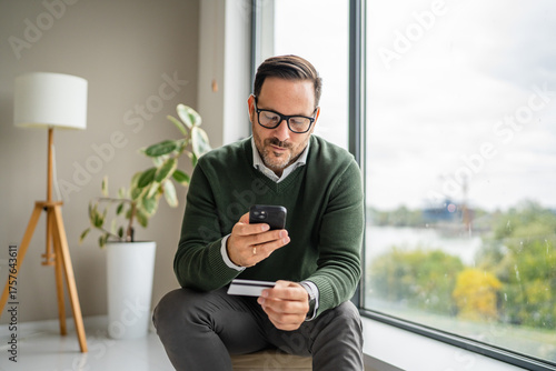 фотографія Man making secure online payment using smart phone and credit card