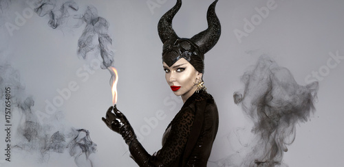Obraz na plátně Dark queen with black horns and red lips in dramatic Halloween portrait Witch wi