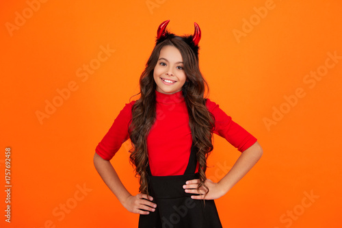 Trick or treat. All Hallows costume party celebration. All Hallows devil. Imp horns. Girl in Halloween imp costume. Happy Halloween. Girl devil in Halloween costume isolated on orange. Tiny devil
