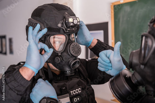 Tactical medic wearing gas mask and giving thumbs up during training exercise