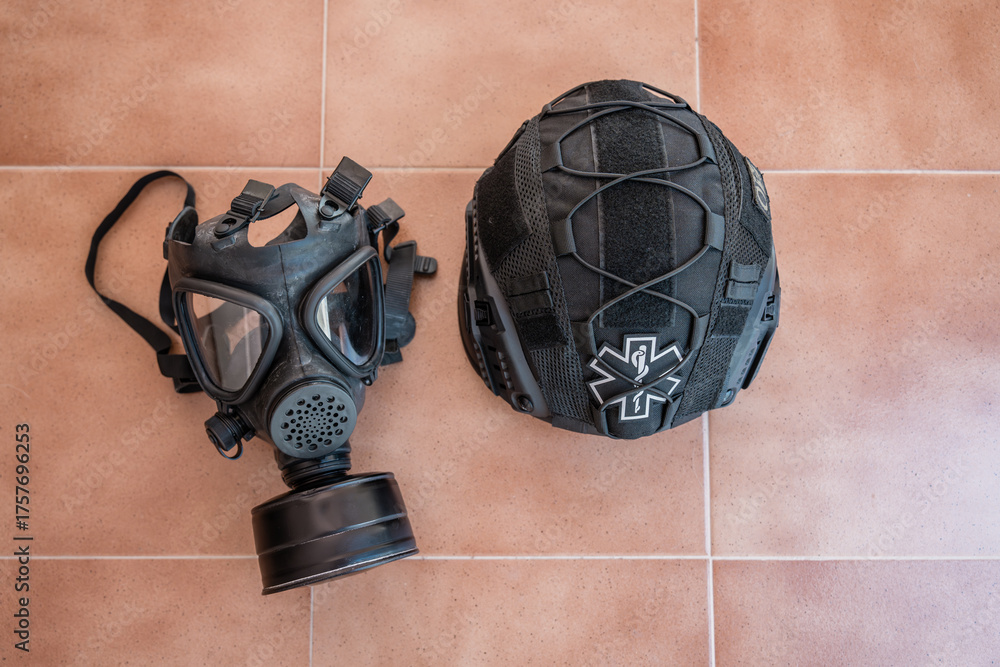 Naklejka premium Gas mask and helmet with star of life symbol lying on tiles