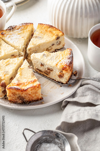 Homemade cottage cheese casserole pie with raisins sliced. Baked cheesecake for healthy breakfast on white table background