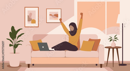 An ecstatic young woman in a hijab triumphantly raises her arms after achieving a personal or professional goal while working from home.