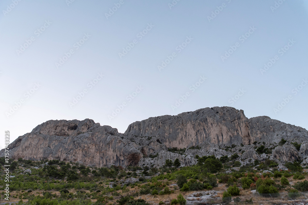 Fototapeta premium Limestone cliff with scrub and clear sky