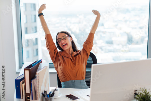 Obraz na płótnie Satisfied businesswoman stretching at workplace after finished work project, sit