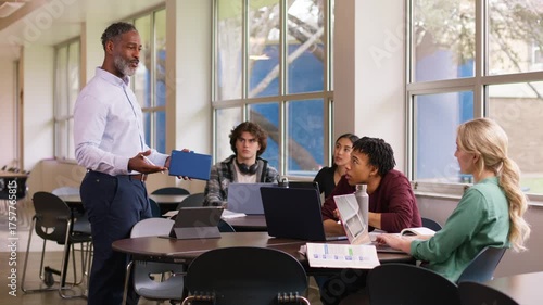 Classroom scene of a teacher engaging with a diverse group of students during a lesson.