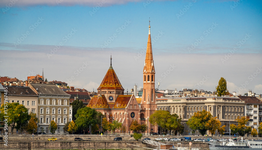 Fototapeta premium Orange colors in Szilágyi Dezső Square Reformed Church from the other side of the Danube River in Budapest