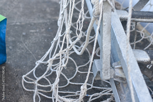 Knot of blue rope. Close-up of weathered blue rope coiled around a metal pulley.	
