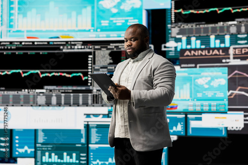 Young businessman thinking about a new solution to increase funds, evaluating statistics and financial reports with digital technology and analytics. Long term success and growth.