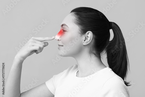 Young woman touching her no...