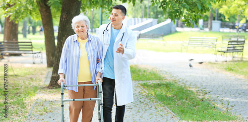 Doctor walking with senior woman in park
