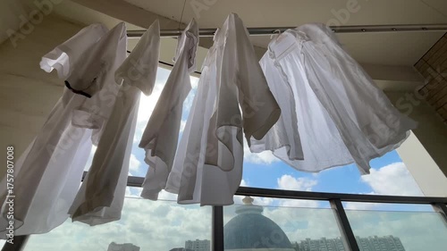 光を受けて白いシャツが青空の下で風に揺れる午後