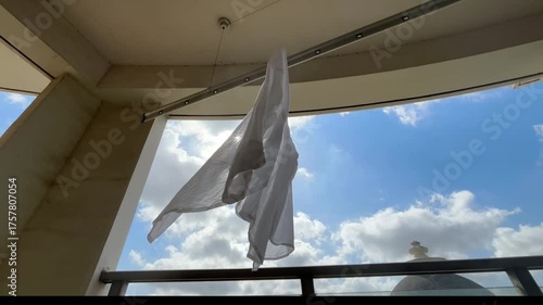 朝の光に照らされ白いシャツが青空の下で風に揺れる