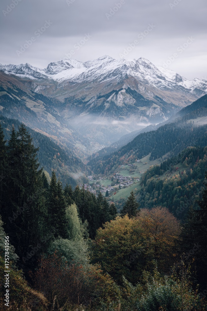 Fototapeta premium Misty mountain valley scene, showcasing snow-capped peaks in the distance, a small village nestled amidst autumnal forests in the foreground, a sense of depth and serenity