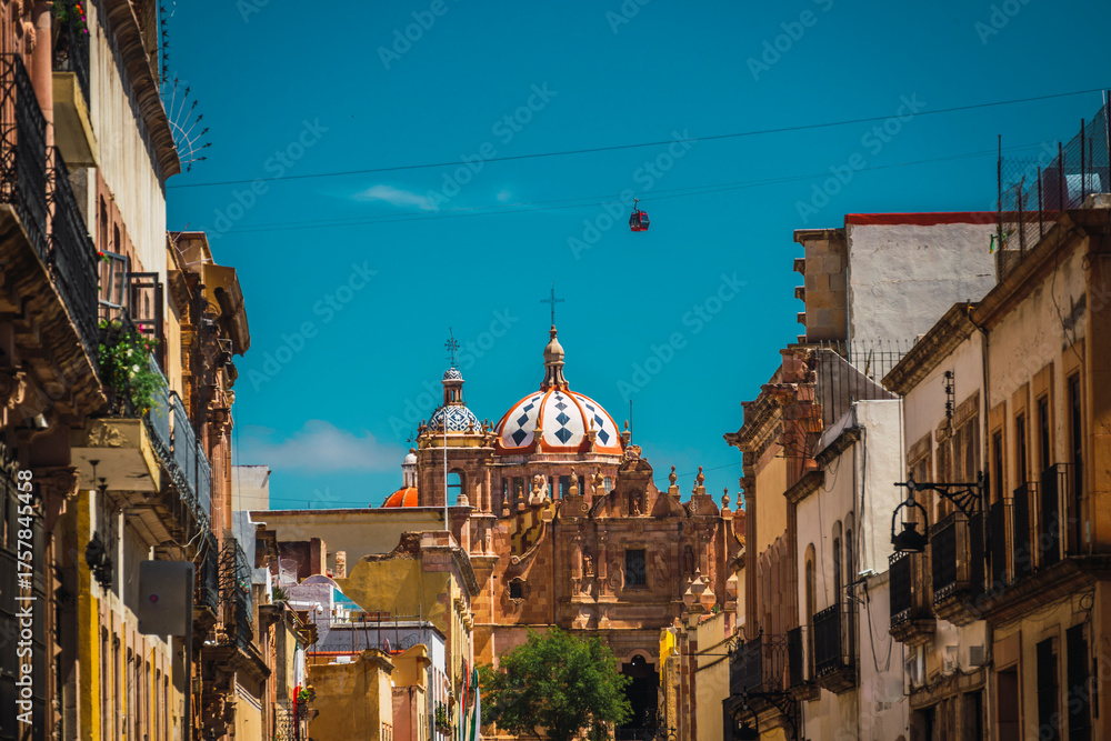 Fototapeta premium Santo Domingo Church accompanied by many colonial-style quarry houses and in the sky the cable car of Zacatecas, Mexico.