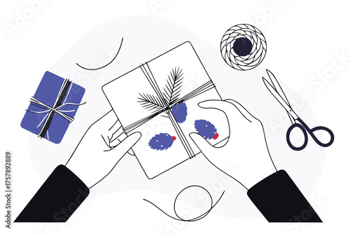 Hands wrapping a gift box with pine sprigs and blue decorative elements isolated on transparent background
